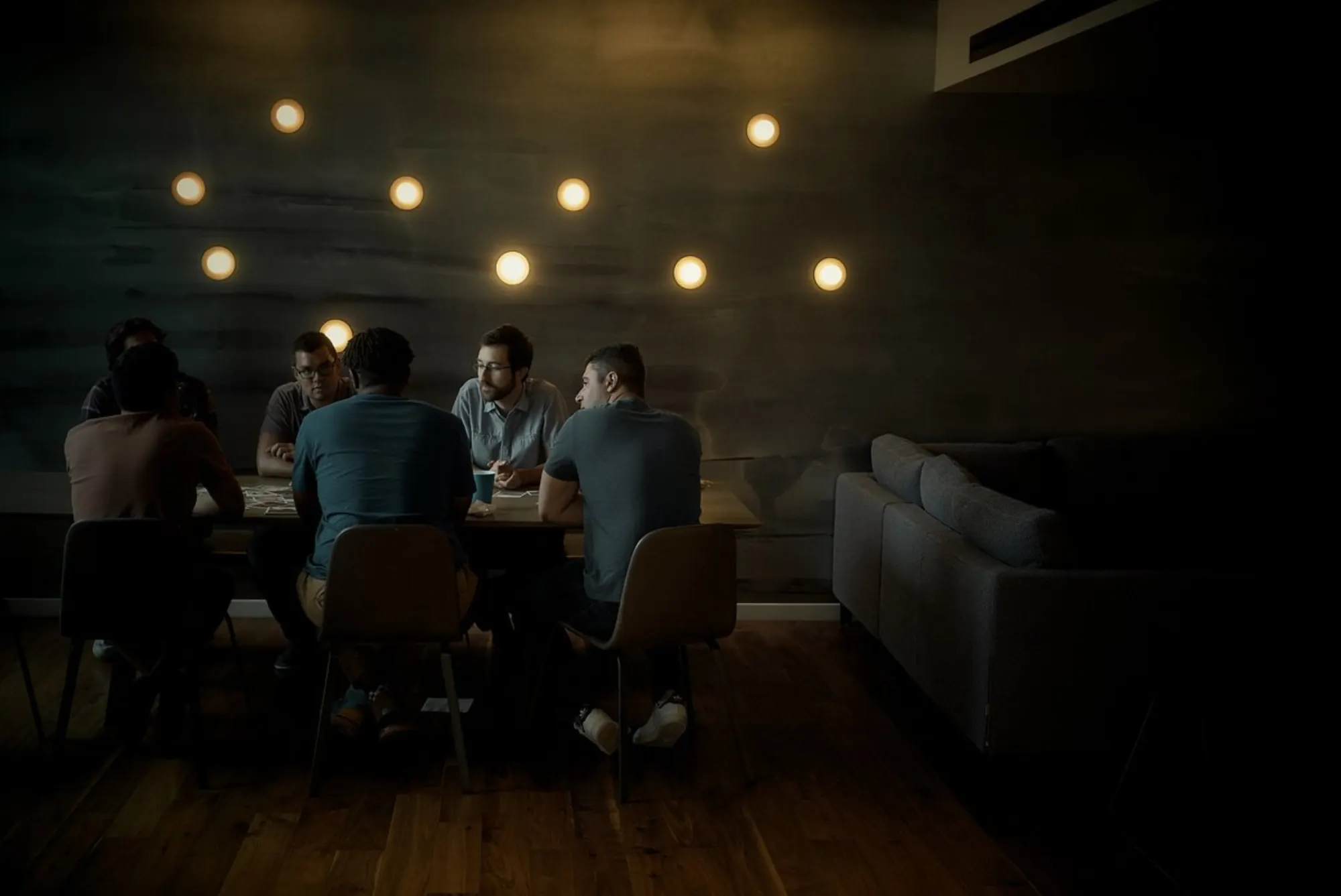 Men gathered around a table under warm lights