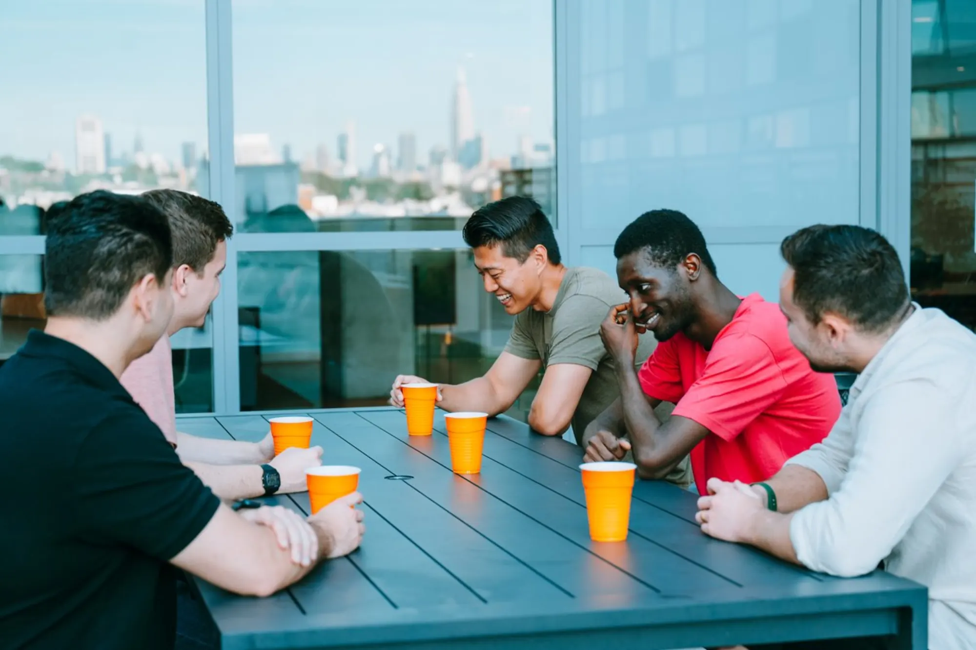 A men's Dinner Group around a rooftop table