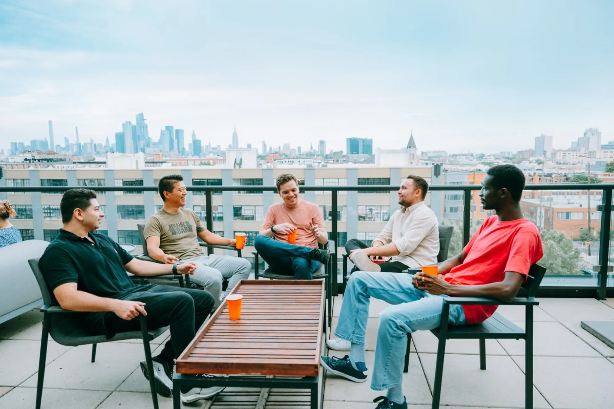 Men talking around a table on a rooftop