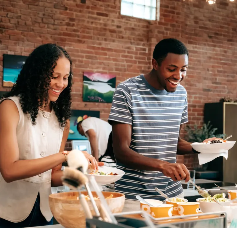A couple serving food at a Dinner Group dinner