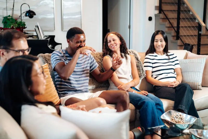 A Dinner Group laughing together on a couch