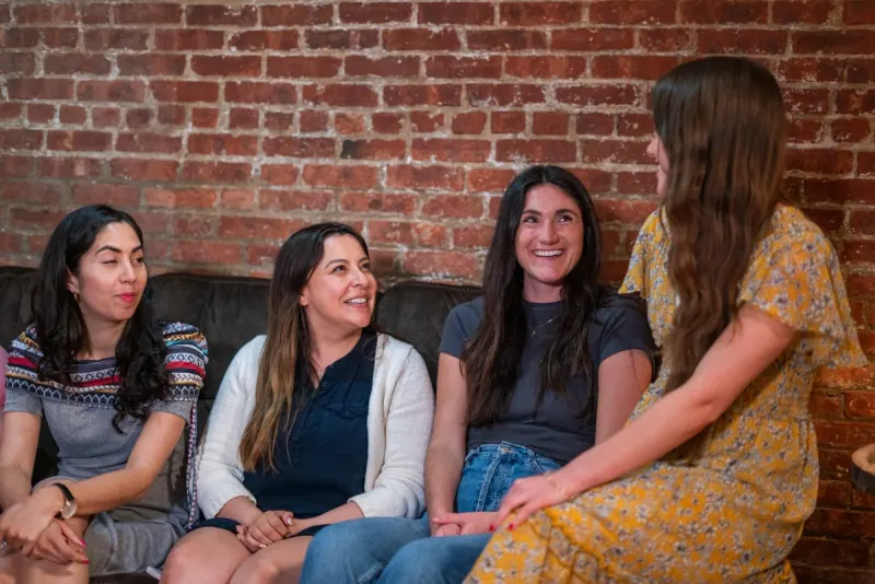 Women laughing together on a couch