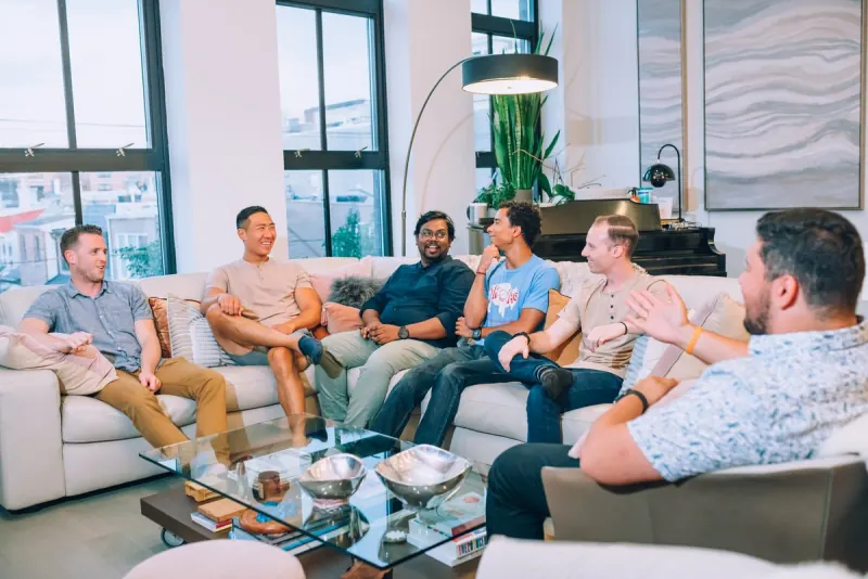 A men's Dinner Group talking on couches