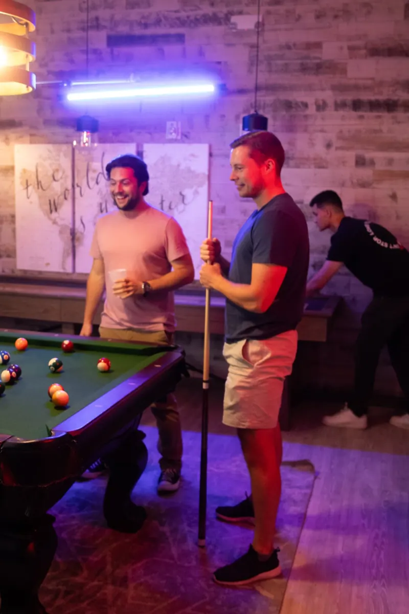 Men playing pool at a Dinner Group hangout